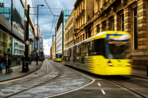Light rail yellow tram in the city center of Manchester